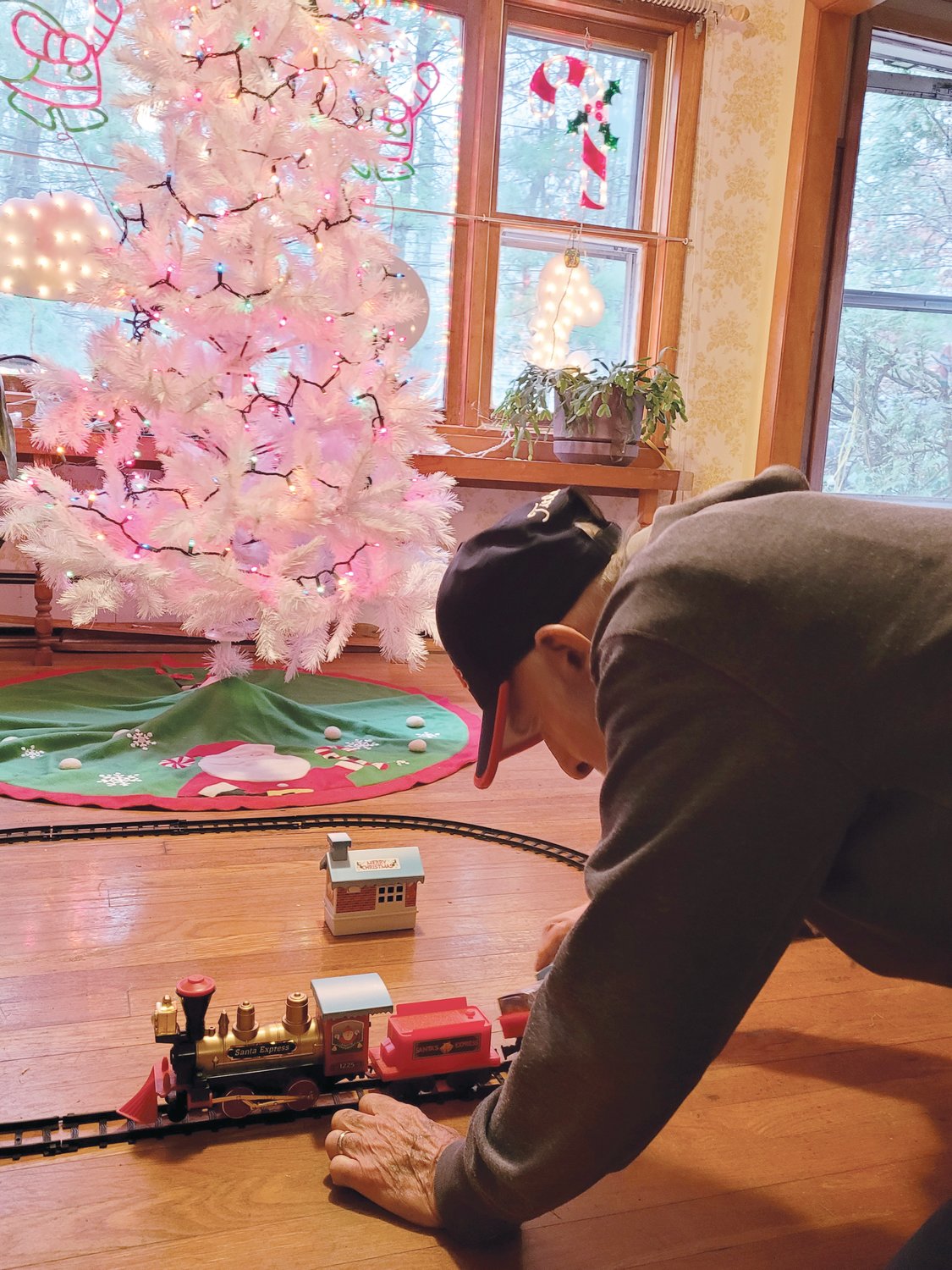 I THINK I CAN: Bernie Pavia kneels down to play with his trainset in his newly remodeled living room. The Korean War veteran’s Johnston home was nearly totaled when a tree fell on it last Christmas. A small group of dedicated workers helped salvage the house, and Pavia’s spirit.